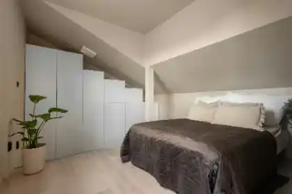 A bed sitting in a bedroom next to a plant