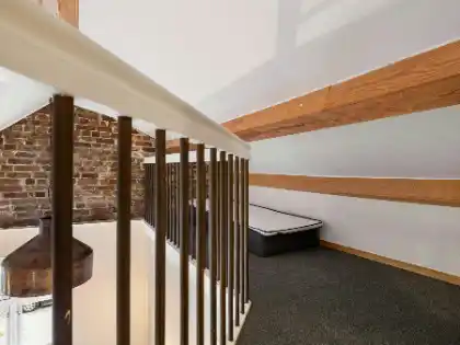 A room with a bed and a brick wall